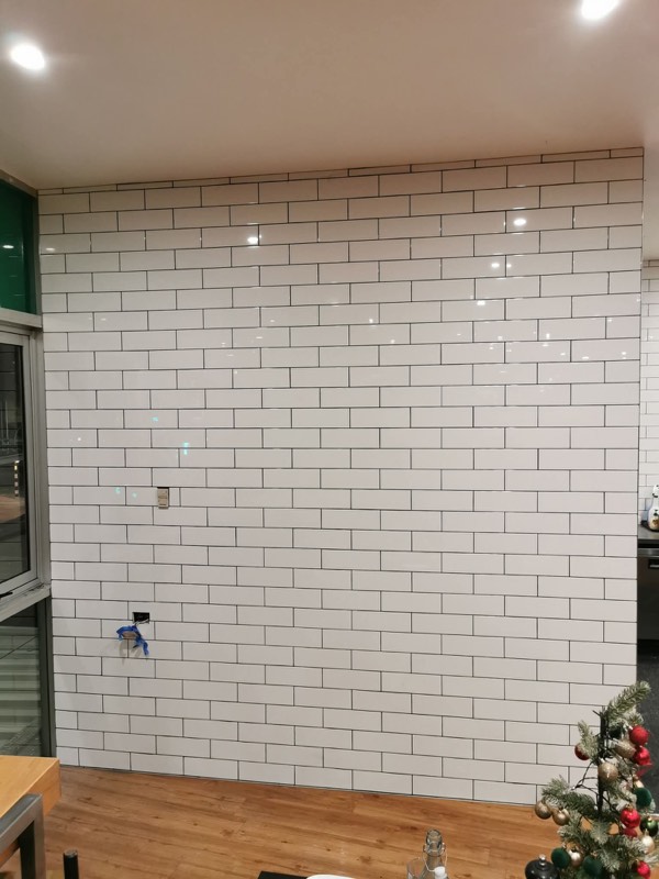 White subway tile feature wall with contrasting dark grout